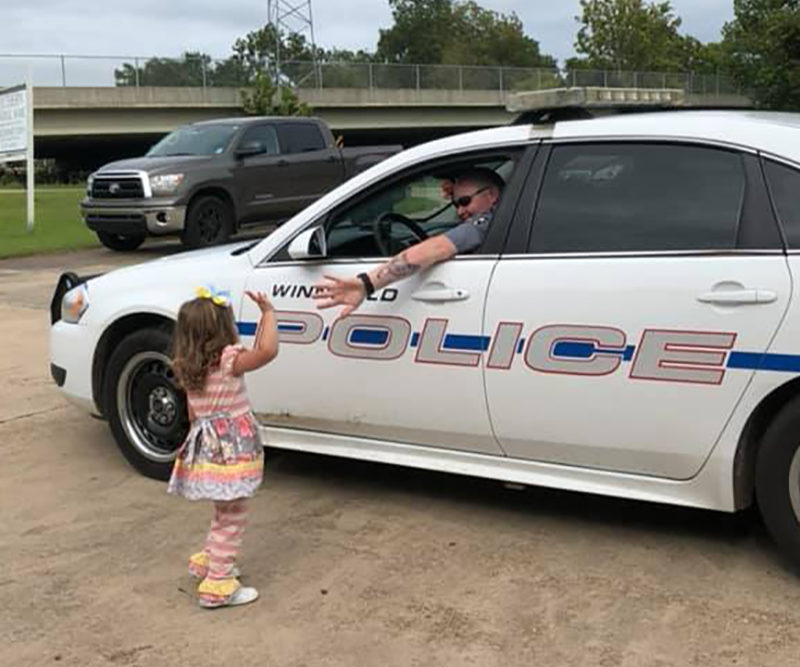 A two year old little girl waving goodbye to the police officer at her daddy's funeral who was also a police officer killed in the line of duty.